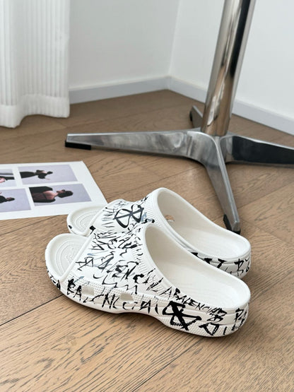 POOL GRAFFITI CROCS SLIDE SANDALS IN WHITE AND BLACK RUBBER